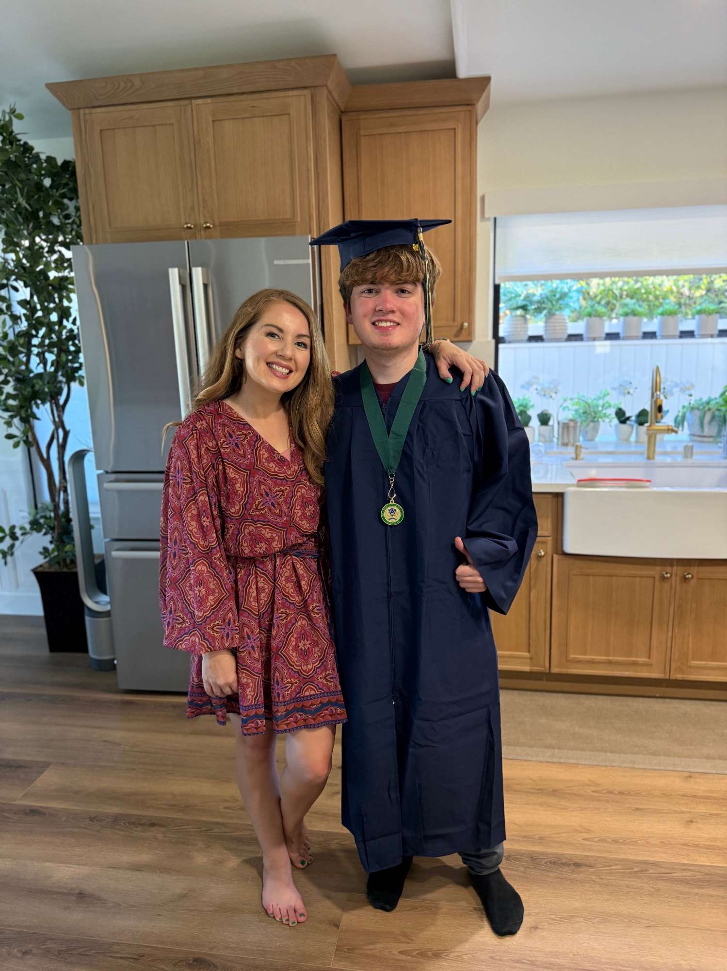 Tera and Robert at home, Robert in cap and gown with a medal
